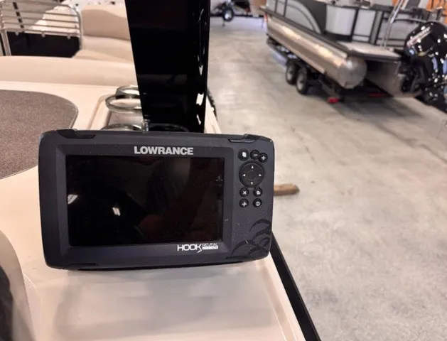 The Image of A Lowrance HOOK device is mounted on a boat. A pontoon boat is visible in the background. - 1