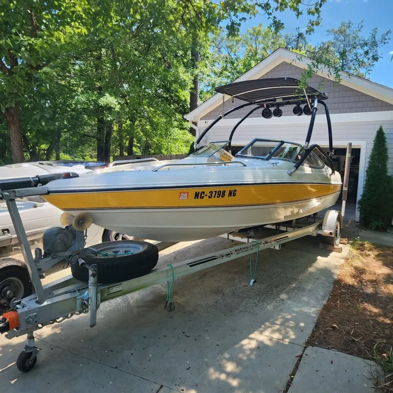 The Image of A 2008 Stingray 185 LS/LX boat on a trailer, parked in front of a house. - 0