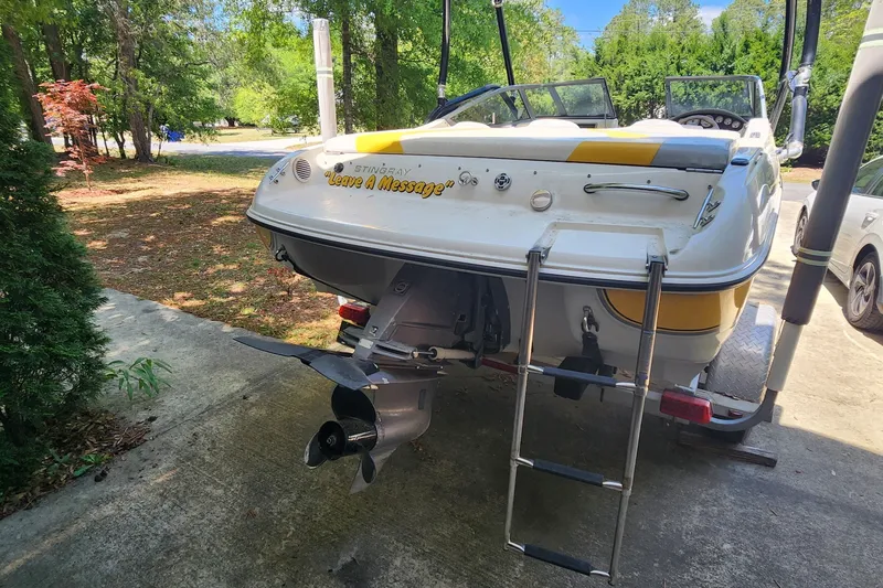 Slide: The Image of 2008 Stingray 185 LS/LX boat with ladder, parked outdoors on a sunny day. - 9