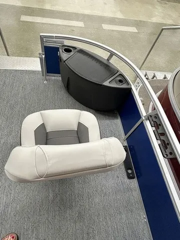 Slide: The Image of A boat with gray carpet flooring and a cushioned seat. There's a black console with cup holders. - 14
