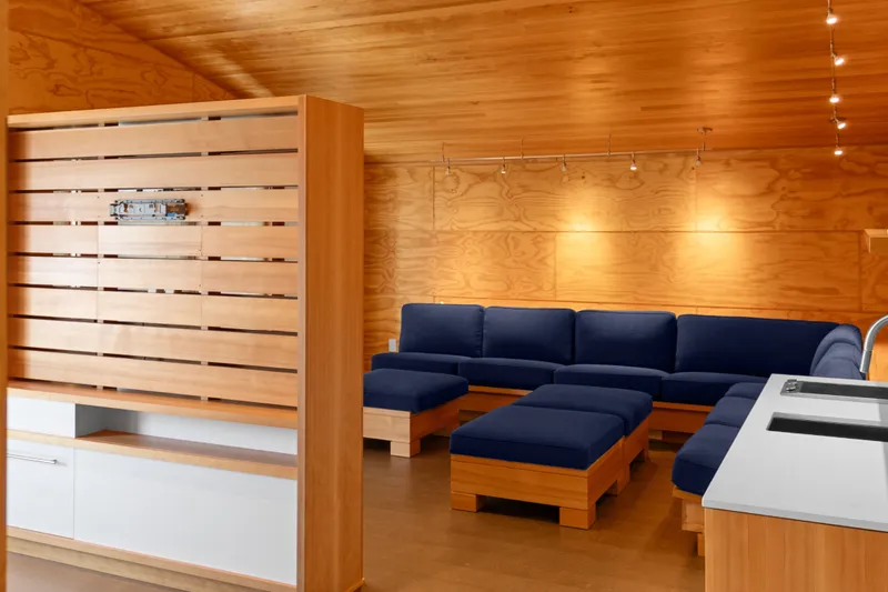 Slide: The Image of Interior of a 1969 Custom All Steel Boathouse with wooden walls and blue seating. - 55