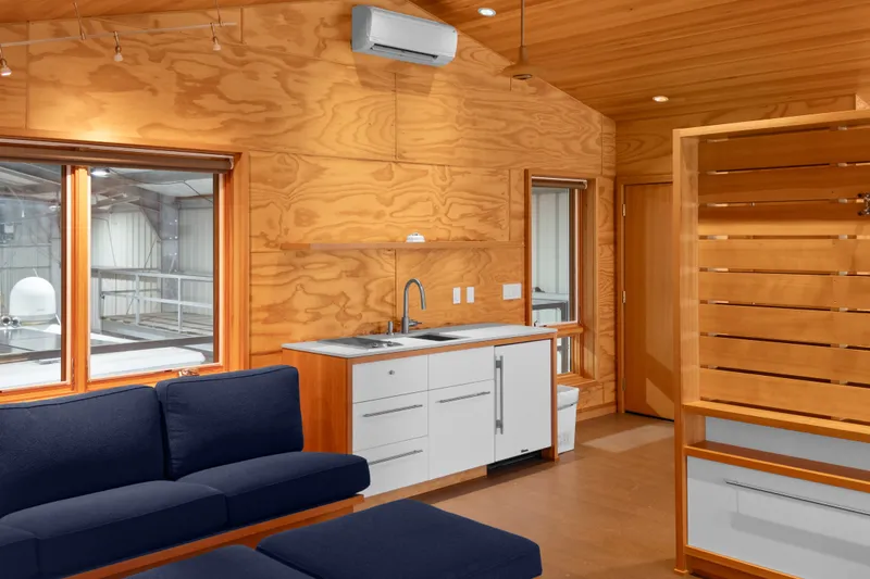 Slide: The Image of Interior of a 1969 Custom All Steel Boathouse with wooden walls and modern furnishings. - 64