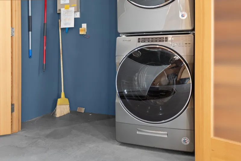 Slide: The Image of Stacked washer and dryer in a modern laundry room with cleaning tools. - 35