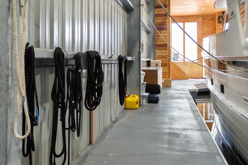 Slide: The Image of Interior of a 1969 Custom All Steel Boathouse with ropes and docked boat. - 27