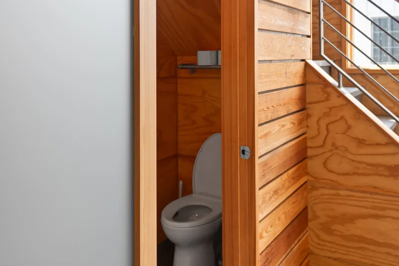 Slide: The Image of Wood-paneled bathroom in a 1969 Custom All Steel Boathouse, featuring a modern toilet design. - 41