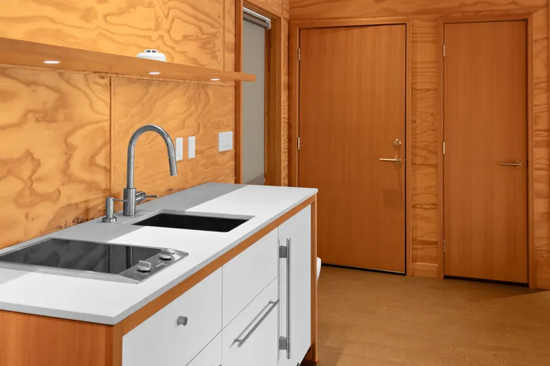 Slide: The Image of Modern kitchen interior in a 1969 Custom All Steel Boathouse with wood paneling and sleek fixtures. - 68