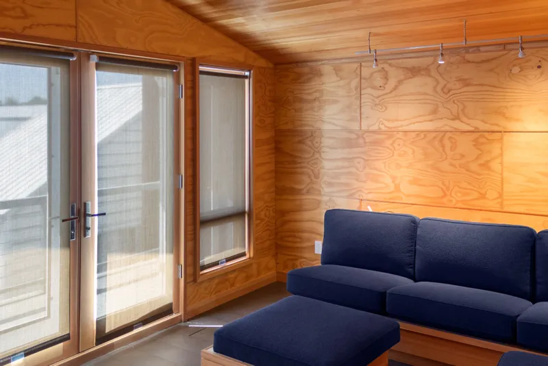Slide: The Image of Interior of a 1969 Custom All Steel Boathouse with wooden walls and blue sofa. - 61