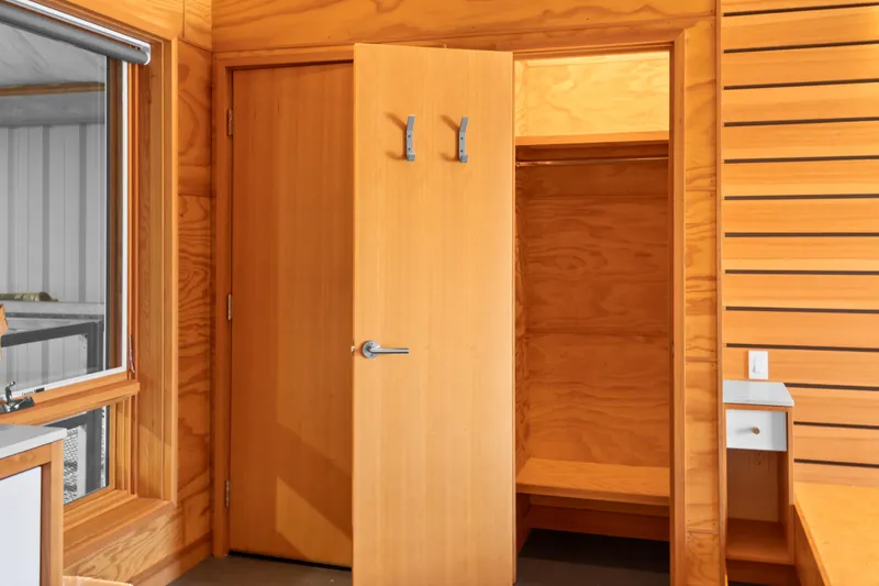 Slide: The Image of Wooden interior of a 1969 Custom All Steel Boathouse with open closet and window. - 57