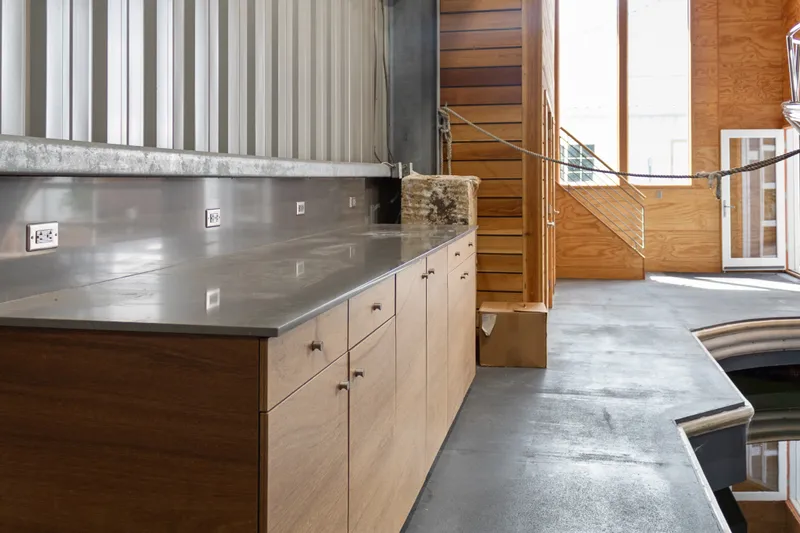 Slide: The Image of Interior of a 1969 custom all-steel boathouse with wooden cabinets and concrete flooring. - 28