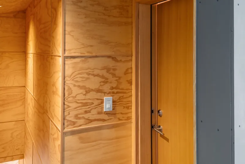 Slide: The Image of Wood-paneled interior with a closed door, featuring a light switch, in a 1969 boathouse. - 52