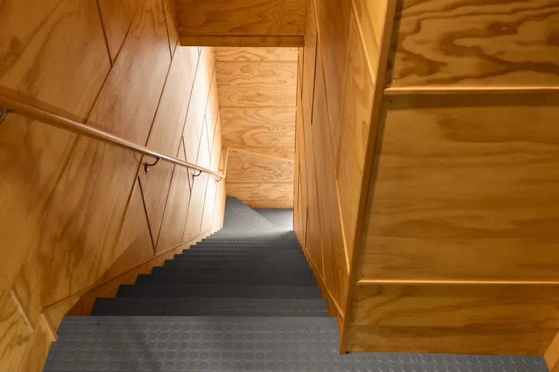 Slide: The Image of Wood-paneled staircase in a 1969 Custom All Steel Boathouse, featuring metal steps and handrail. - 47