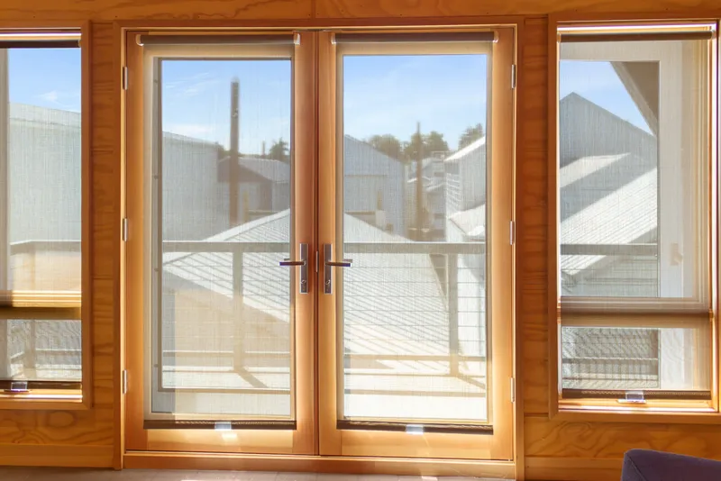 Slide: The Image of Wood-framed glass doors with sheer curtains in a 1969 Custom All Steel Boathouse. - 71