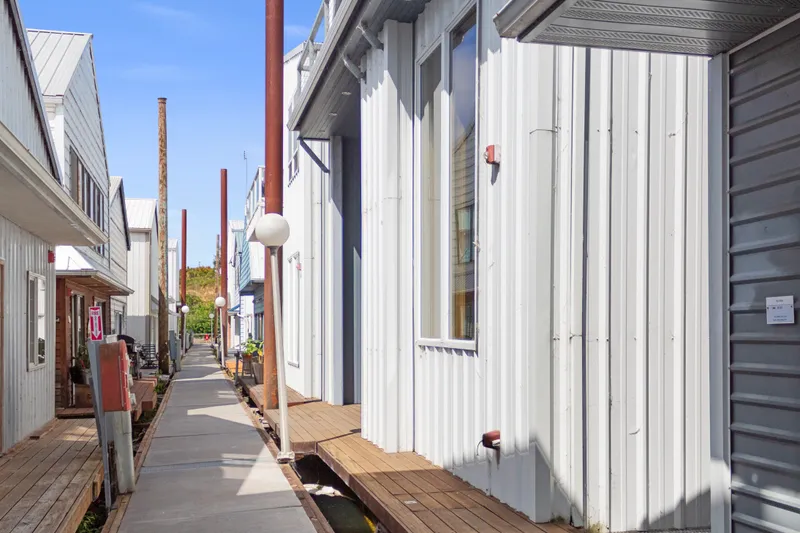 Slide: The Image of Narrow walkway between custom all-steel boathouses, built in 1969, under clear blue sky. - 13