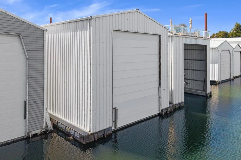 Slide: The Image of Custom All Steel Boathouse, 2008 model, with white exterior on calm water. - 6