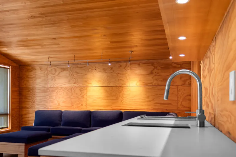 Slide: The Image of Modern boathouse interior with wooden walls, blue sofa, and sleek kitchen faucet, 1969 design. - 66