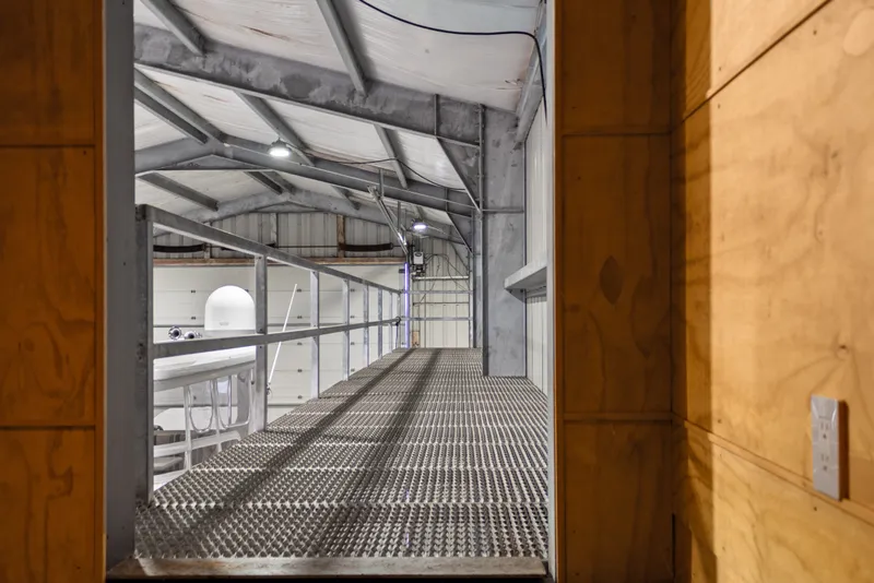 Slide: The Image of Interior view of a 1969 Custom All Steel Boathouse with metal walkway and industrial lighting. - 45