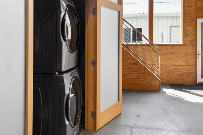 Slide: The Image of Modern laundry area in a 1969 Custom All Steel Boathouse with wooden accents and natural light. - 37