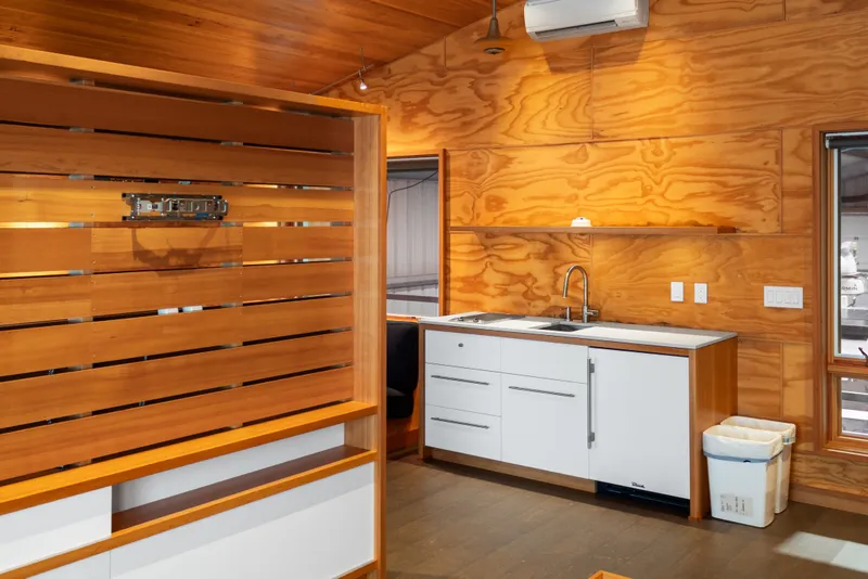 Slide: The Image of Modern kitchen interior in a 1969 Custom All Steel Boathouse with wood paneling and white cabinetry. - 59