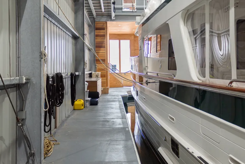 Slide: The Image of Interior of a 1969 Custom All Steel Boathouse with docked yacht and storage area. - 26
