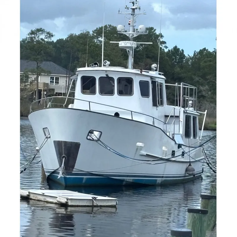 The Image of A white boat anchored in the water, with a small dinghy beside it. - 0