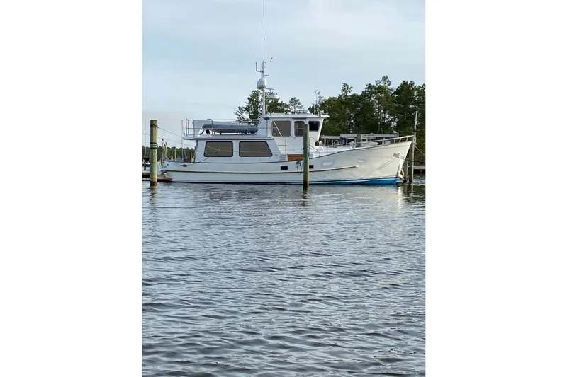 Slide: The Image of 1988 Hans Christian Independence 45 yacht docked on calm water, surrounded by trees. - 2