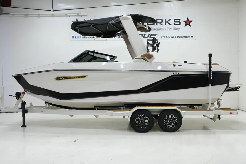 Slide: The Image of A white 2027 Nautique G23 boat on a trailer in a showroom. - 4