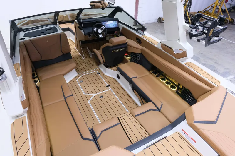 Slide: The Image of The image shows the interior of a 2027 Nautique G23 boat with luxurious brown seating. - 12