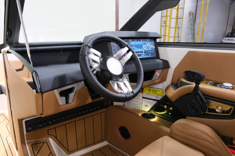 Slide: The Image of The cockpit of a 2027 Nautique G23 with a modern steering wheel and touchscreen display. - 14