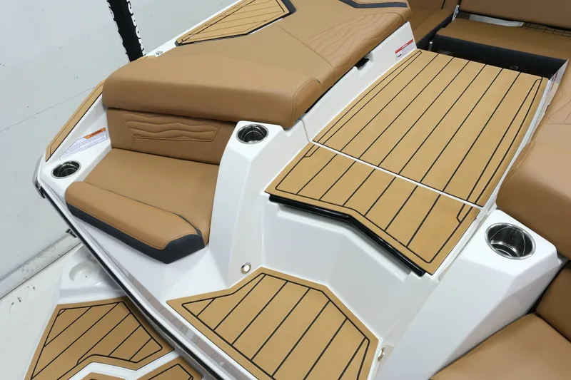 Slide: The Image of The image shows the deck of a 2027 Nautique G23 with brown upholstery and wood flooring. - 21