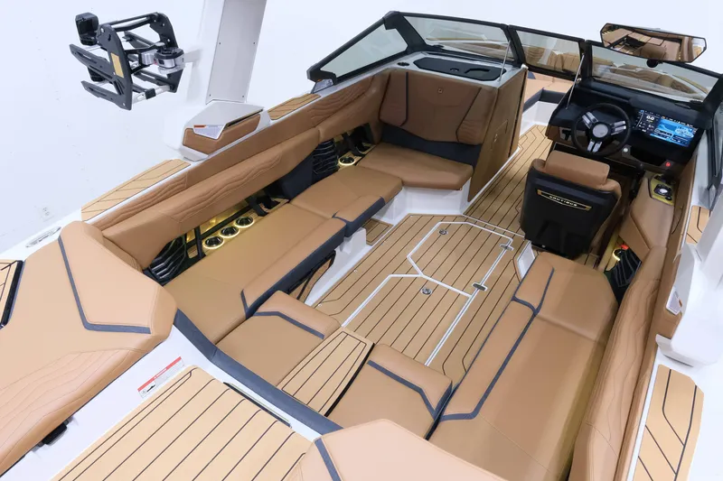 Slide: The Image of The image shows the interior of a 2027 Nautique G23 boat with sleek brown seating and modern controls. - 11