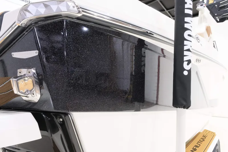 Slide: The Image of The image shows the sleek black stern of a 2027 Nautique G23 boat. - 7
