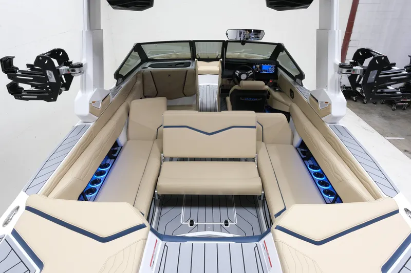 Slide: The Image of The image shows the interior of a 2027 Nautique G25 boat with beige seating and blue lighting. - 10