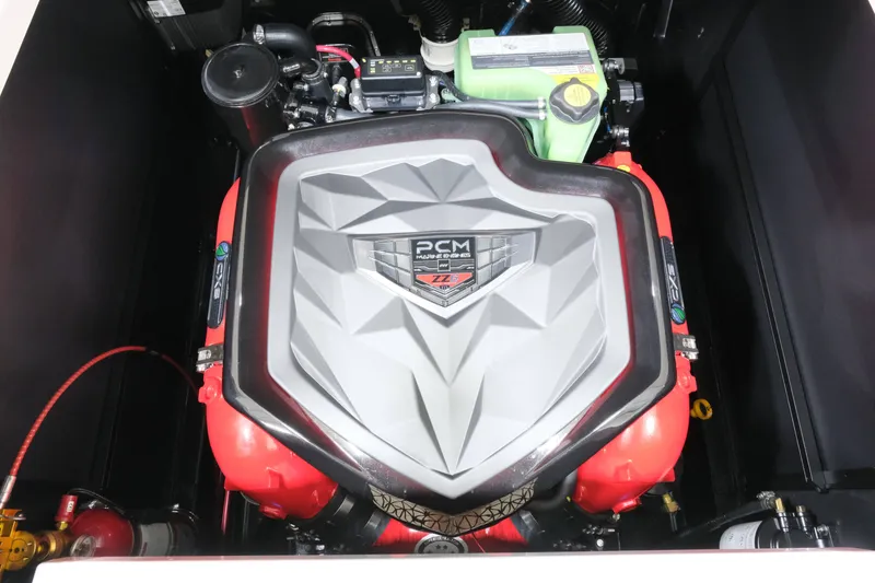 Slide: The Image of The engine compartment of a 2027 Nautique G25 features a powerful PCM engine with red covers. - 23