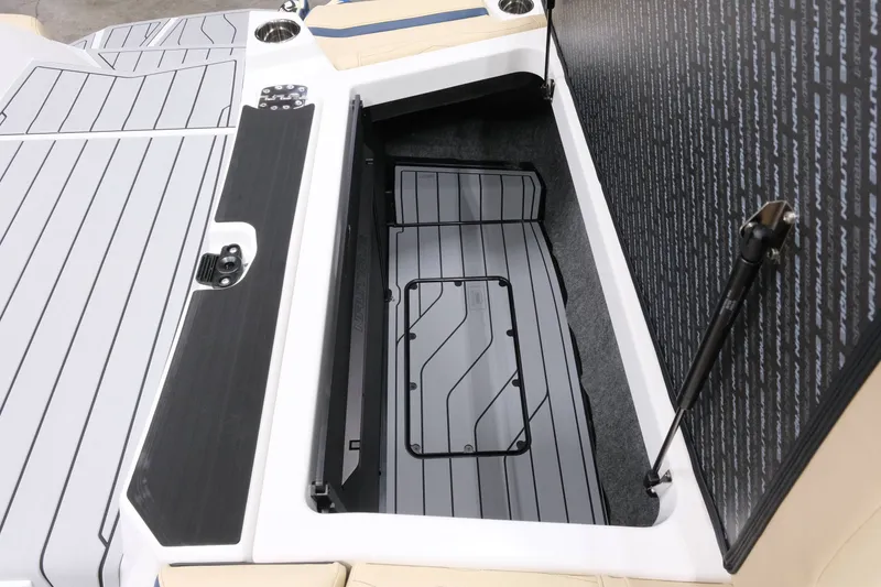Slide: The Image of The image shows the storage compartment of a 2027 Nautique G25 boat with gray flooring. - 22