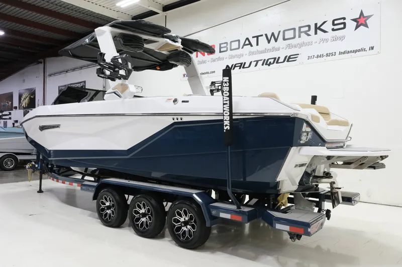 Slide: The Image of A modern 2027 Nautique G25 sits on a trailer in a showroom. - 6