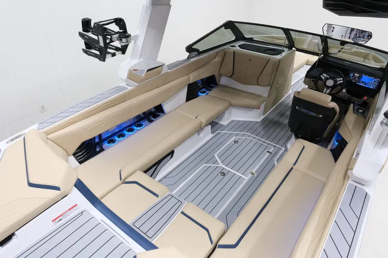 Slide: The Image of The image shows the interior of a 2027 Nautique G25 boat with beige seating and blue lighting. - 11