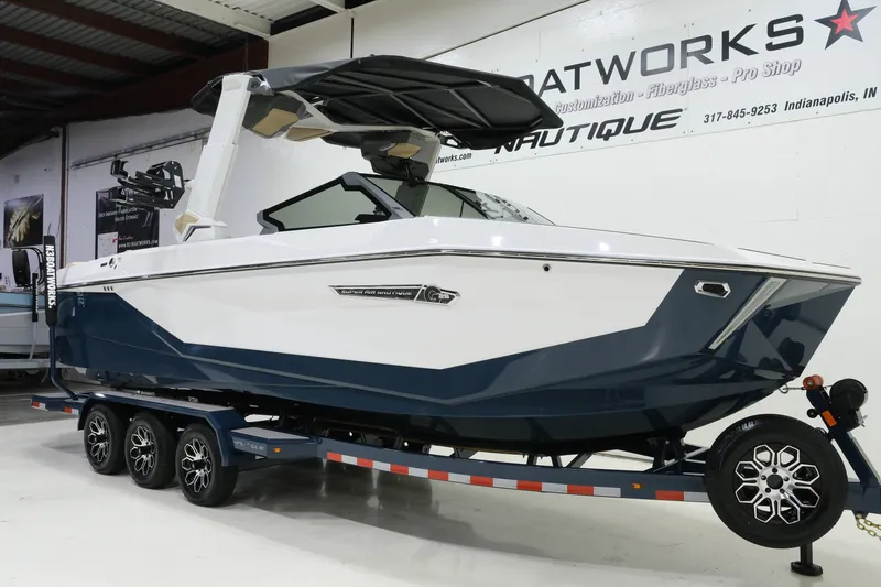 Slide: The Image of A modern 2027 Nautique G25 sits on a trailer in a showroom. - 2