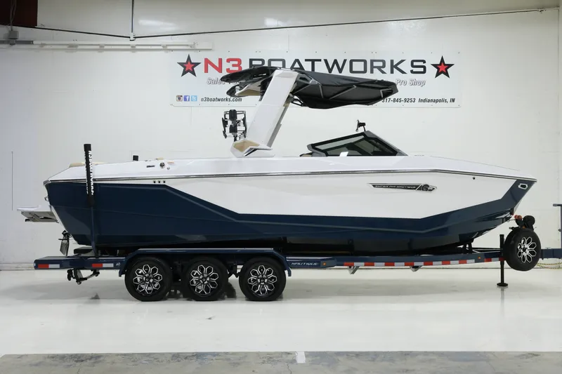 The Image of A modern 2027 Nautique G25 on a trailer in a showroom. - 1