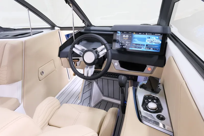 Slide: The Image of The image shows the cockpit of a 2027 Nautique G25 with a modern steering wheel and large display. - 13