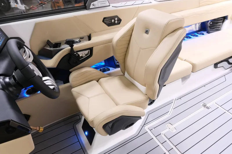 Slide: The Image of The image shows the interior of a 2027 Nautique G25 with a beige leather seat and blue lighting. - 15