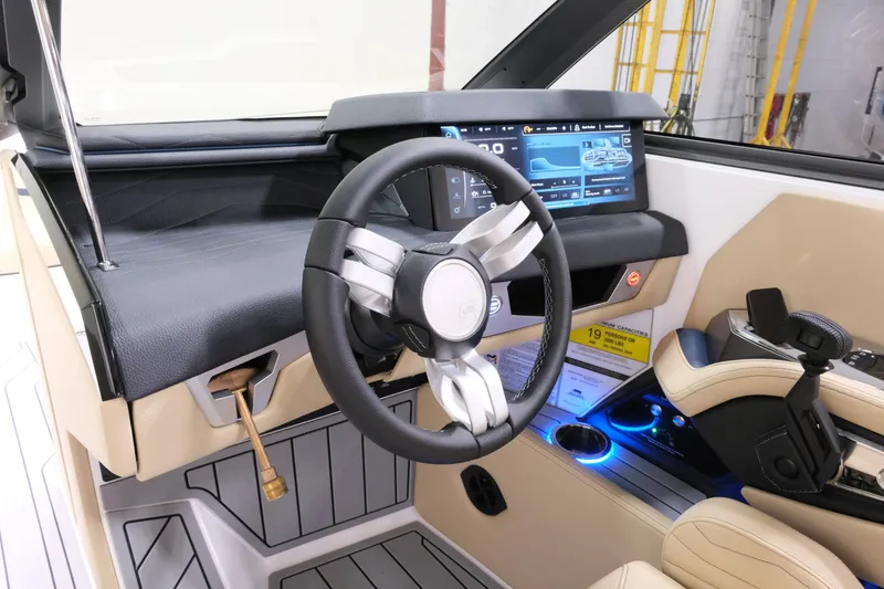 Slide: The Image of The image shows the cockpit of a 2027 Nautique G25 boat with a modern steering wheel and touchscreen. - 14