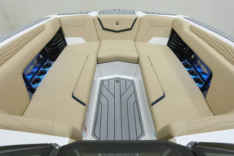 Slide: The Image of The image shows the bow area of a Nautique G25 boat with beige upholstery and blue lighting. - 16