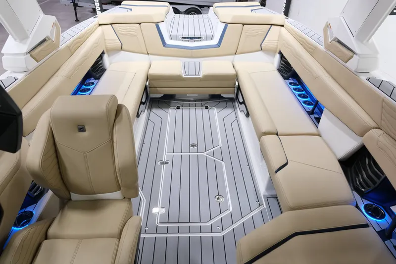 Slide: The Image of The image shows the luxurious interior of a Nautique G25 boat with beige upholstery and blue lighting. - 18
