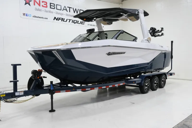 Slide: The Image of A 2027 Nautique G25 boat on a trailer in a showroom. - 5