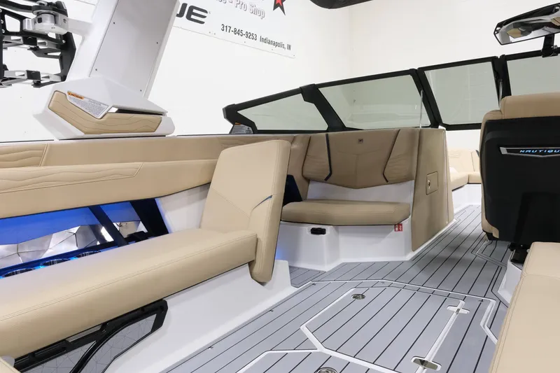 Slide: The Image of The image shows the interior of a 2027 Nautique G25 boat with beige seats and gray flooring. - 17