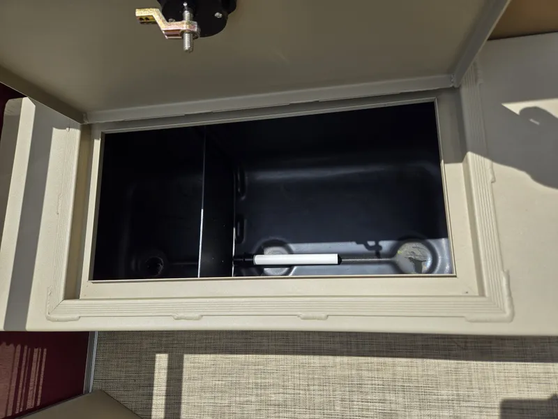 Slide: The Image of An open storage compartment on a 2020 Lowe SF 232 boat, featuring a black interior. - 15