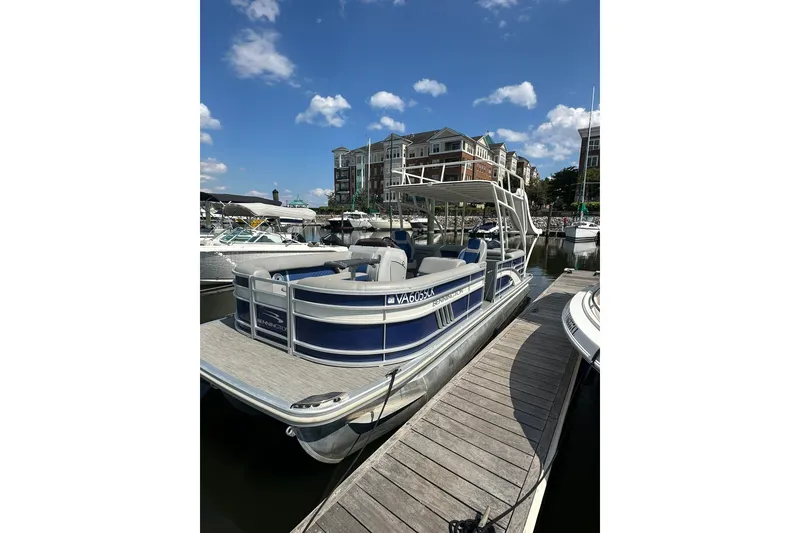 The Image of 2021 Bennington L Bowrider 25 Swingback pontoon boat docked at marina. - 1