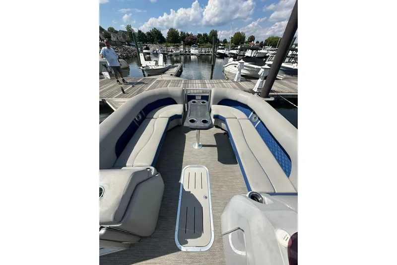 Slide: The Image of 2021 Bennington L Bowrider 25 Swingback at marina, featuring spacious seating and modern design. - 11