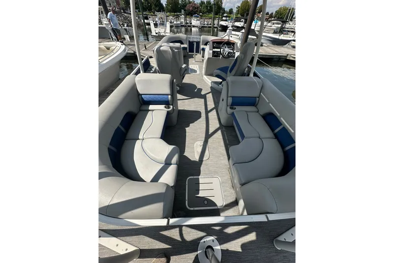 Slide: The Image of 2021 Bennington L Bowrider 25 Swingback interior with plush seating at marina. - 8