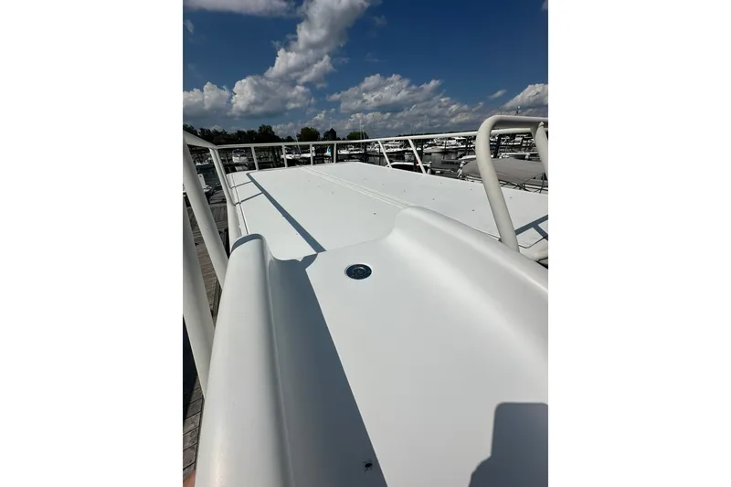 Slide: The Image of 2021 Bennington L Bowrider 25 Swingback deck under a clear blue sky. - 4
